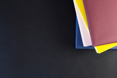 Siyah arkaplan üzerine kitap yığını