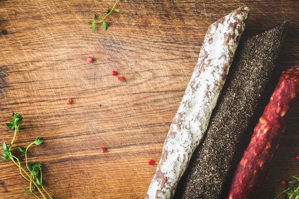 Три вида испанских колбас на деревянной доске — стоковое фото