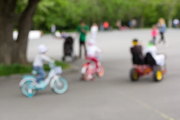 Immagine sfocata e sfocata dell'attività del bambino: i bambini in sella alle loro biciclette — Foto Stock