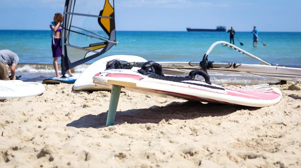 Windsurfbrett mit Segel im Sand liegend — Stockfoto