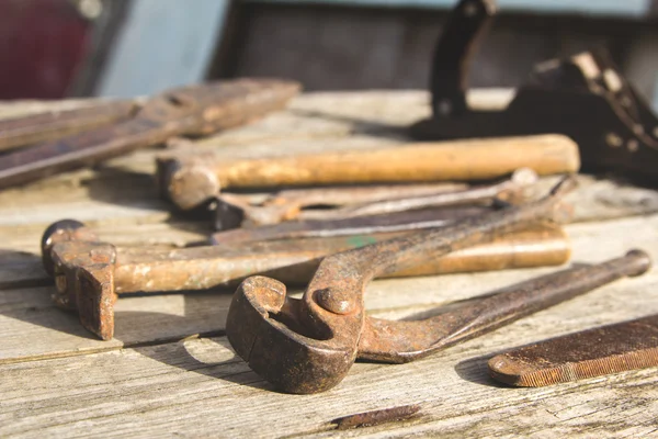 Conjunto oxidado de herramientas manuales sobre un fondo de madera. Foto vintage —  Fotos de Stock