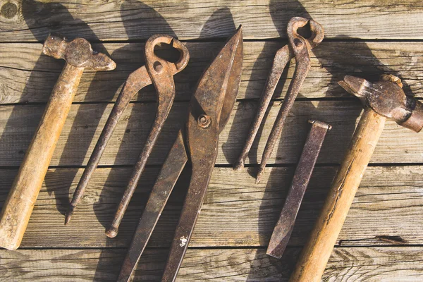 Conjunto oxidado de herramientas manuales sobre un fondo de madera. Foto vintage —  Fotos de Stock