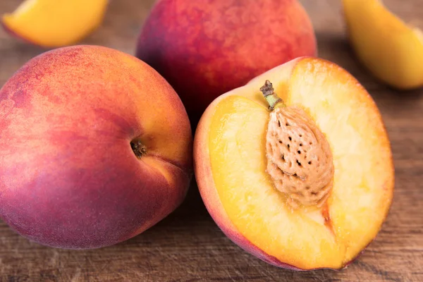 Ahşap kesme tahtası üzerinde taze şeftali.