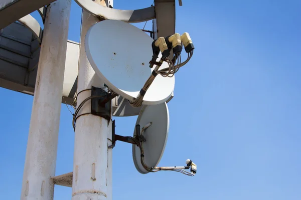 Antenna satellitare sul pilastro con cielo blu — Foto Stock