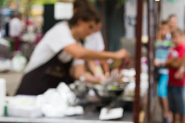 Şef sokak gıda olayı üzerinde yemek pişiriyor. Bulanık fotoğraf