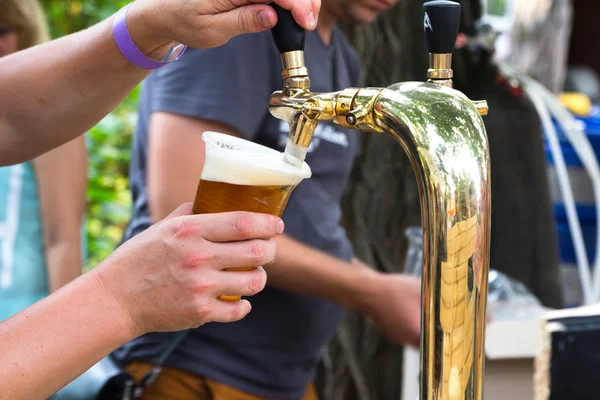 Bira musluk için plastik cam dökülen adam eller