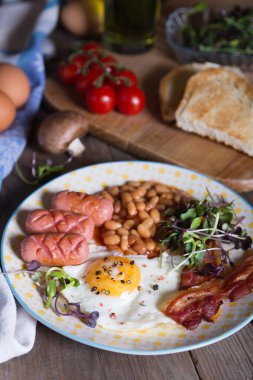 Domuz pastırmalı yumurta, sosis ve domates soslu fasulye, İngiliz kahvaltısı.