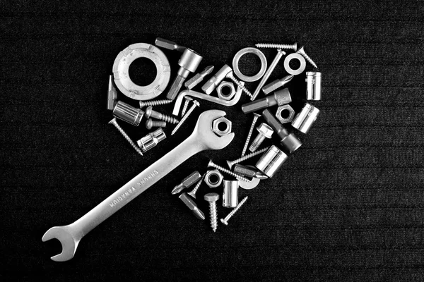 Corazón de las herramientas y tuercas de tornillo en negro —  Fotos de Stock