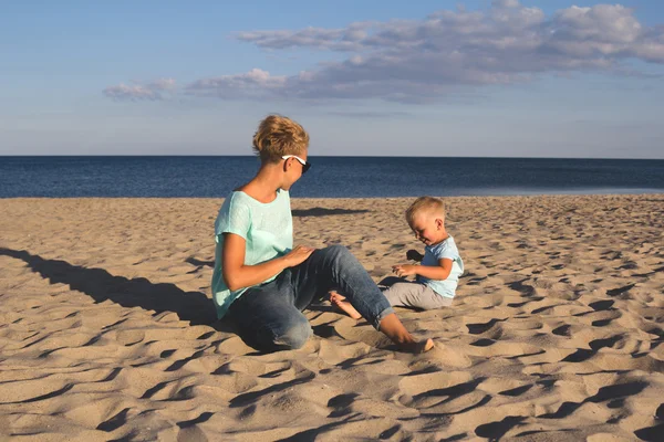 Glückliche Familie ruht sich im Sommer am Strand aus — Stockfoto