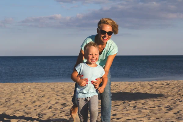 Glückliche Familie ruht sich im Sommer am Strand aus — Stockfoto