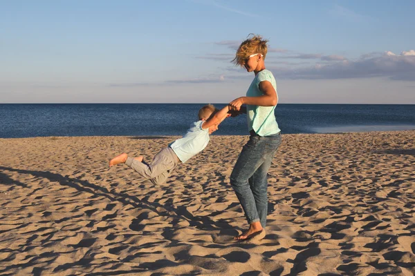 Glückliche Familie ruht sich im Sommer am Strand aus — Stockfoto