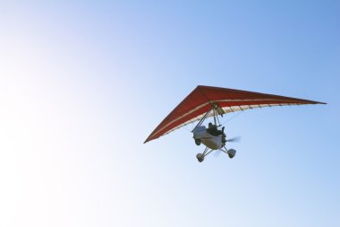 Motorlu hang glider mavi gökyüzünde süzülen