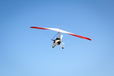 Motorlu hang glider mavi gökyüzünde süzülen