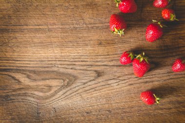 Eski ahşap arka planda taze çilekler.