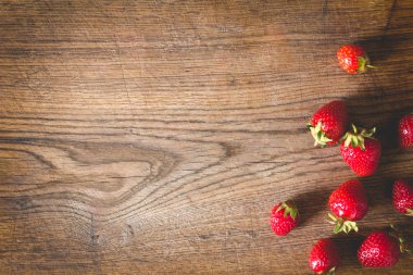 Eski ahşap arka planda taze çilekler.