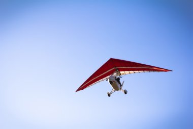 Motorlu hang glider mavi gökyüzünde süzülen
