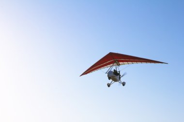 Motorlu hang glider mavi gökyüzünde süzülen