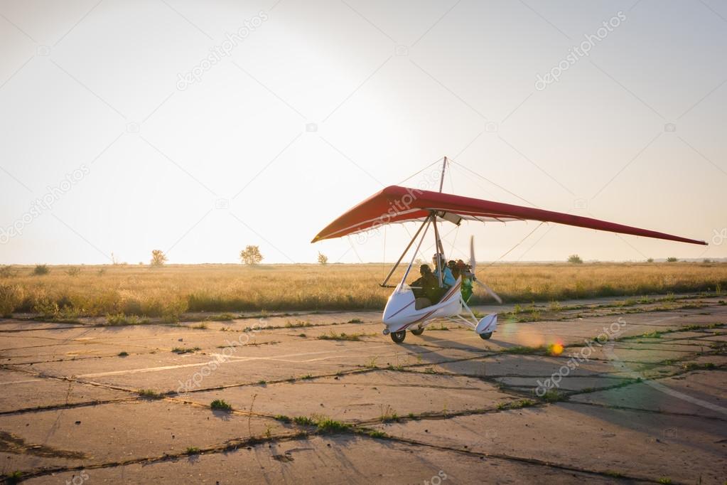 Hang-gliding, standing at dawn on the runway