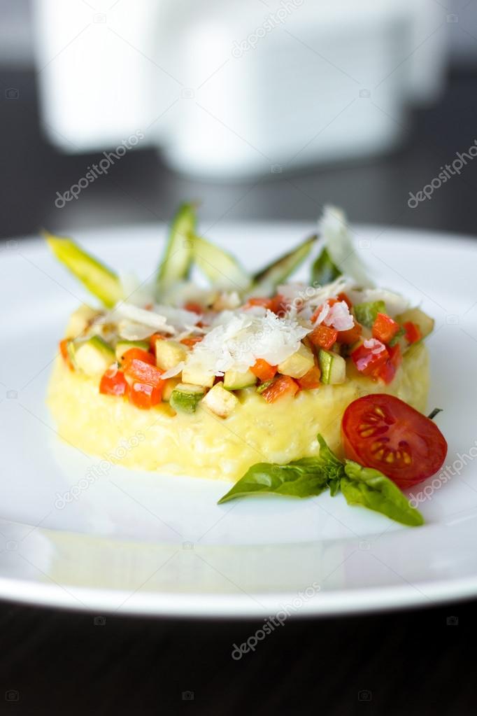 risotto with cheese and vegetables on white plate