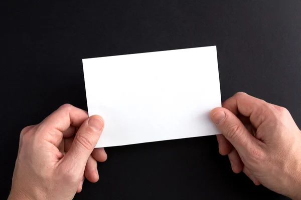 Männer halten ein weißes Blatt Papier in den Händen — Stockfoto