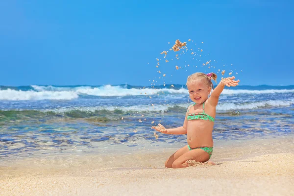 Criança feliz brincando com diversão na praia de areia do mar — Fotografia de Stock