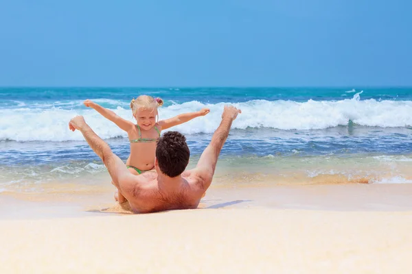 Uomo con il bambino che gioca con il divertimento sulla spiaggia di sabbia di mare — Foto Stock