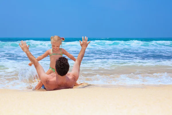 Homem com criança brincando com diversão na praia de areia do mar — Fotografia de Stock
