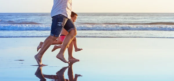 Blote voeten benen van familie draait op strand — Stockfoto