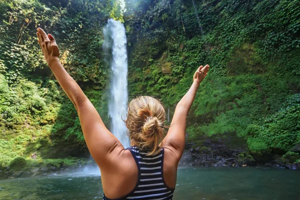 Linda feliz jovem viajando na floresta selvagem de Bali espalhando mãos curtindo a natureza tropical Cachoeira fresco. Excursão de dia de natureza, caminhadas de atividade de aventura e diversão nas férias de verão família. — Fotografia de Stock