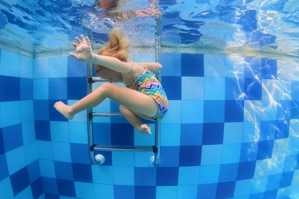 Klein kind met plezier zwemmen en duiken neer in zwembad — Stockfoto
