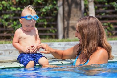Mutlu çocuk yüzme havuzunda güzel kadınla