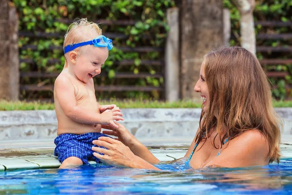 Happy baby boy simma med vacker mor i poolen — Stockfoto