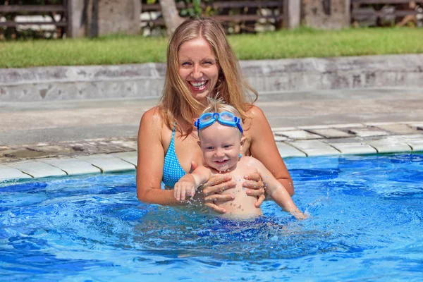 Boldog gyermek úszás a medencében gyönyörű anya — Stock Fotó