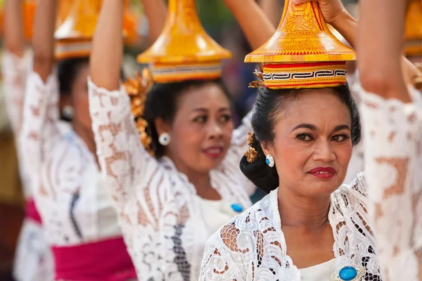 Denpasar, ilha de Bali, Indonésia - 13 de junho de 2015: Grupo de mulheres lindas em trajes tradicionais balinesas carregam na cabeça oferta religiosa para cerimônia hindu em desfile no festival de arte e cultura. — Fotografia de Stock