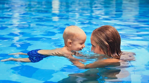 Lilla barnet simmar i poolen med mamma — Stockfoto