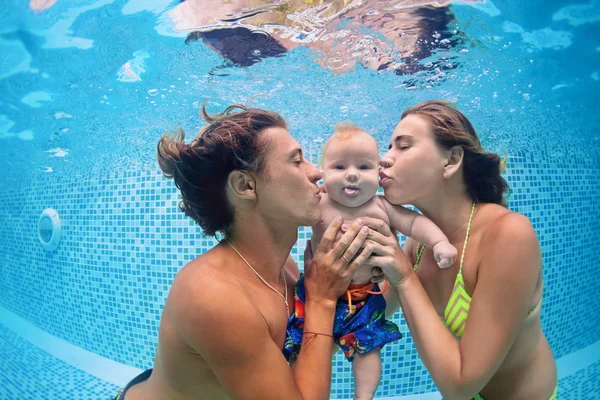 Bebê com os pais aprender a nadar debaixo de água na piscina — Fotografia de Stock