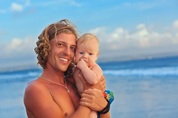 Familie fericită pe plaja de apus de soare - tatăl ține copilul fiu — Fotografie, imagine de stoc
