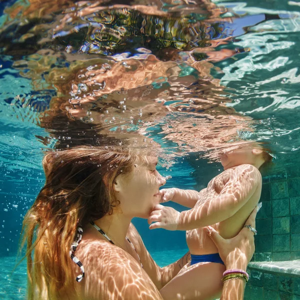 Moeder, baby zwemmen en duik onder water in zwembad — Stockfoto