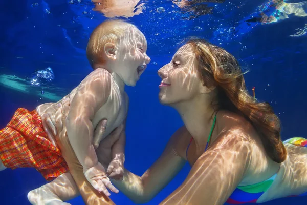 Mãe, o filho nadar e mergulhar debaixo d'água na piscina — Fotografia de Stock