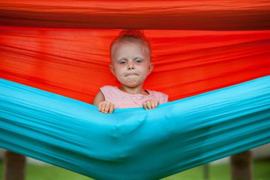 Sallanan hamakta takılan komik kız. Mutlu aile, tropik sahil beldesinde iyi eğlenceler. Aktif çocuk yaşam tarzı, yaz tatilindeki çocuklu insanlar..