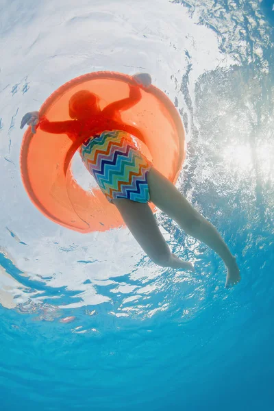 有趣的水下照片 小女孩在水上公园或海滩游泳池的橙色充气管子上游泳 家庭旅游生活方式 孩子们在暑假与父母一起参加水上体育活动 — 图库照片