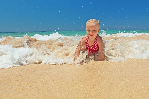 Little girl playing in ocean surf — Stock Photo, Image
