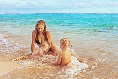 Anne ve kızı ve oğlu deniz sahilde