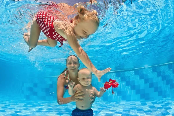 Baby underwater swimming lesson with instructor in the pool — Stock Photo, Image