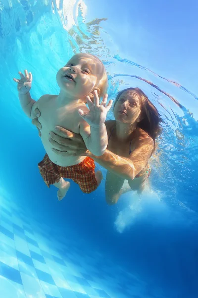 Mãe com criança nadar debaixo de água na piscina — Fotografia de Stock