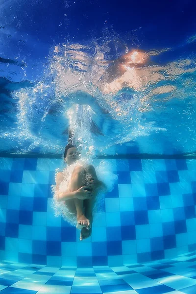 Fille de natation saute profondément vers le bas sous l'eau dans la piscine bleue — Photo