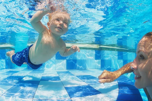 Petit enfant nageant sous l'eau dans la piscine avec la mère — Photo