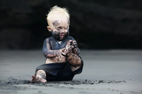 Portrait of dirty child on the black san beach —  Fotos de Stock