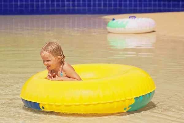 Funny portrait of cheerful baby girl swimming in water park — Stock Photo, Image