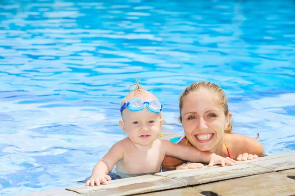 Funny portrait of baby boy swimming with mother in pool — Stock Photo, Image